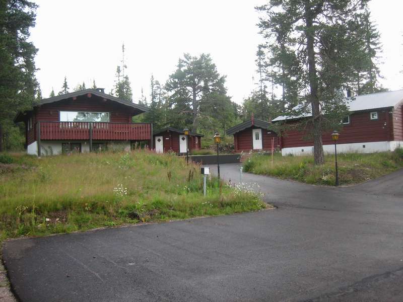 En bild över gården Gäststugan längst till höger Fjällboden med 2 vita dörrar
