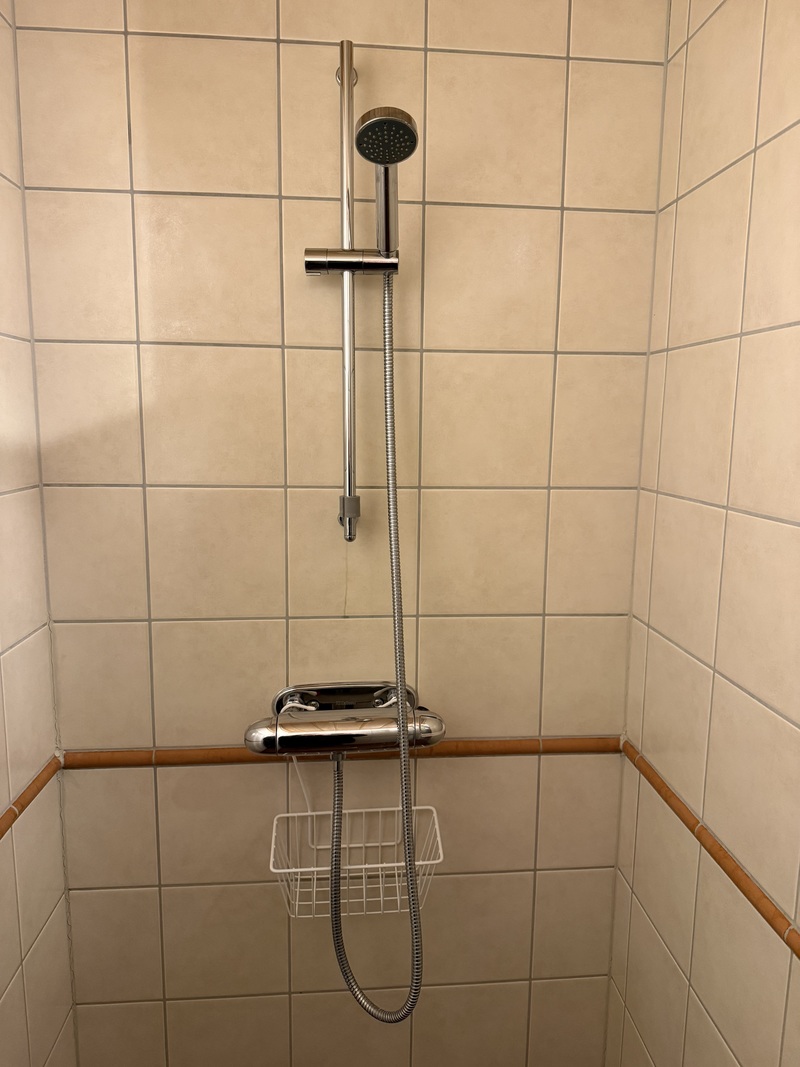 Spaavdelning med två duschar, en toa, bastu, vinkyl samt fotöljer